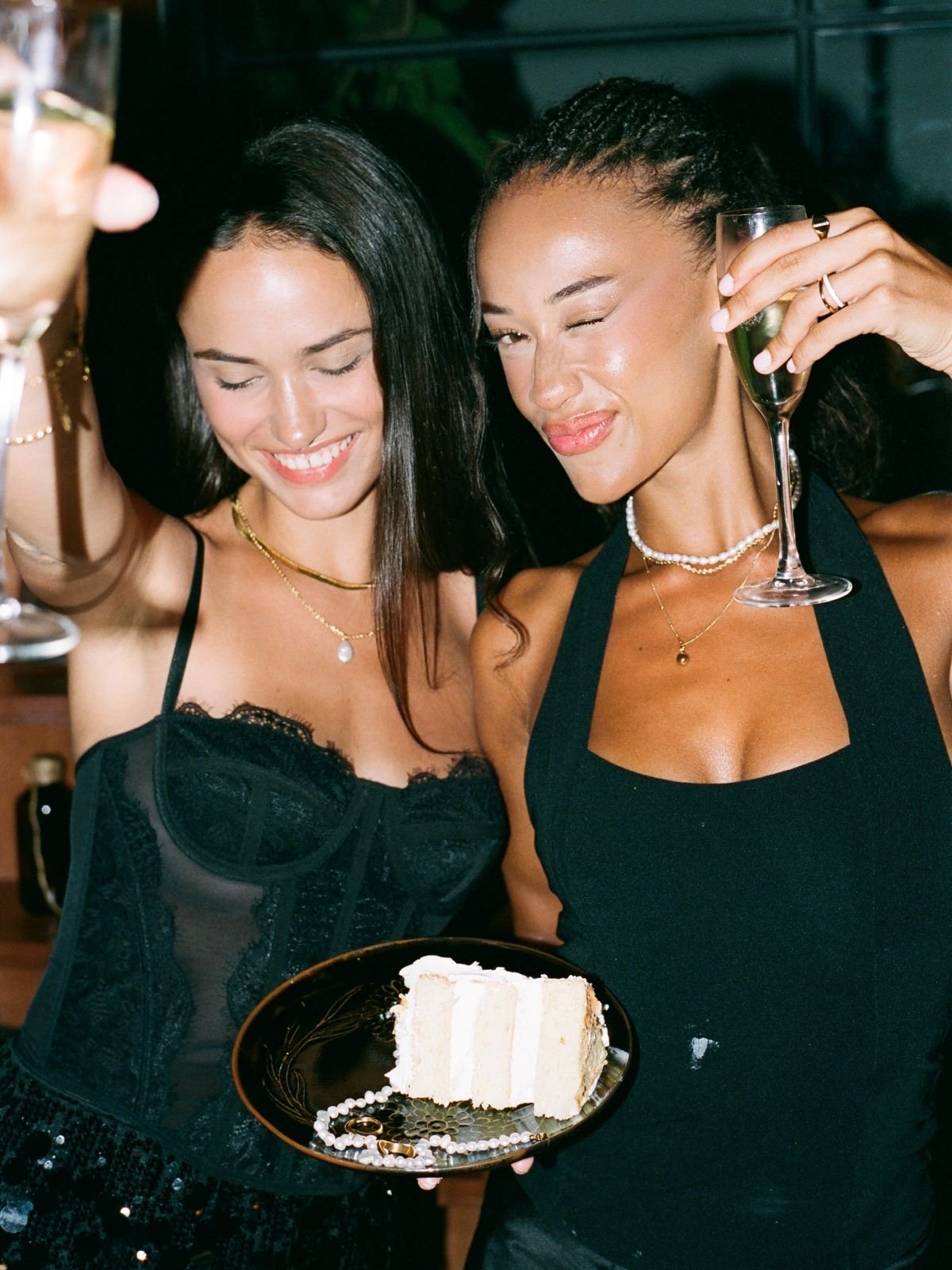 Two Peache girls toasting with champagne and cake