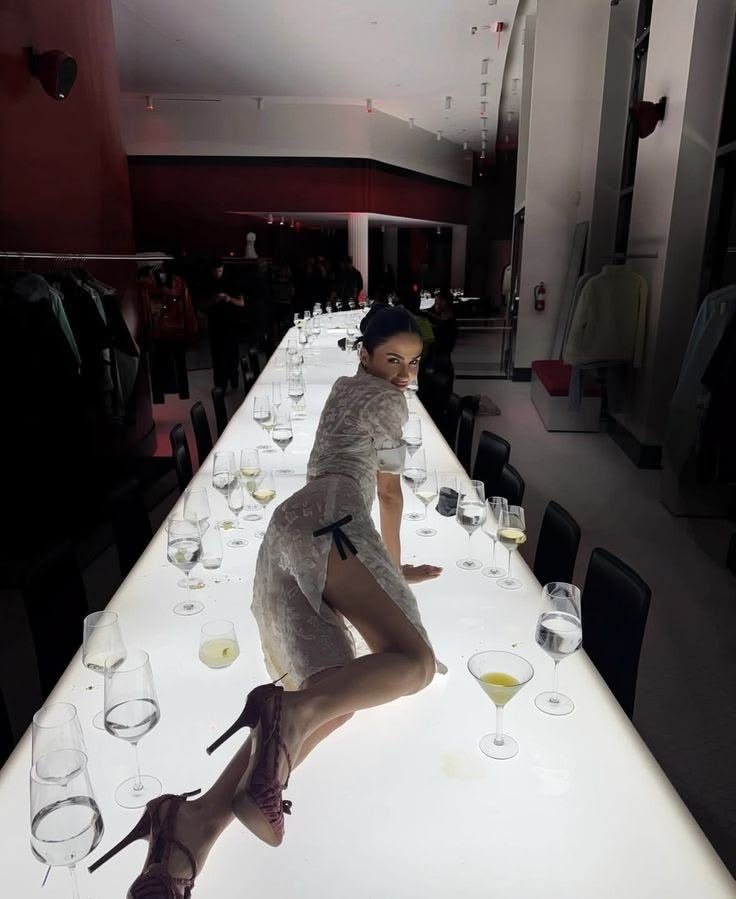 A girl lying along a lit dinner table